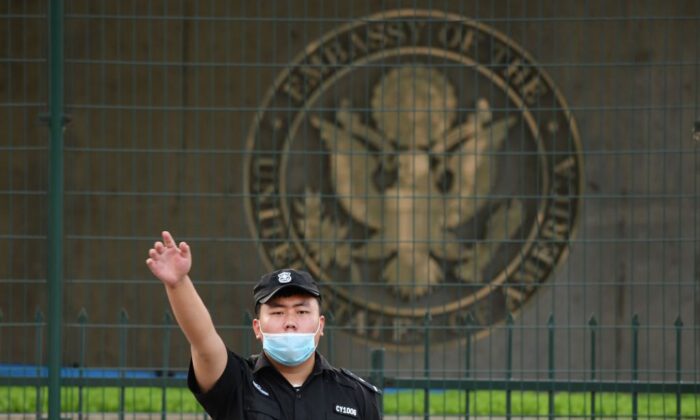 Китайский охранник жестикулирует возле посольства США в Пекине, 12 сентября 2020 года. (Greg Baker/AFP via Getty Images)