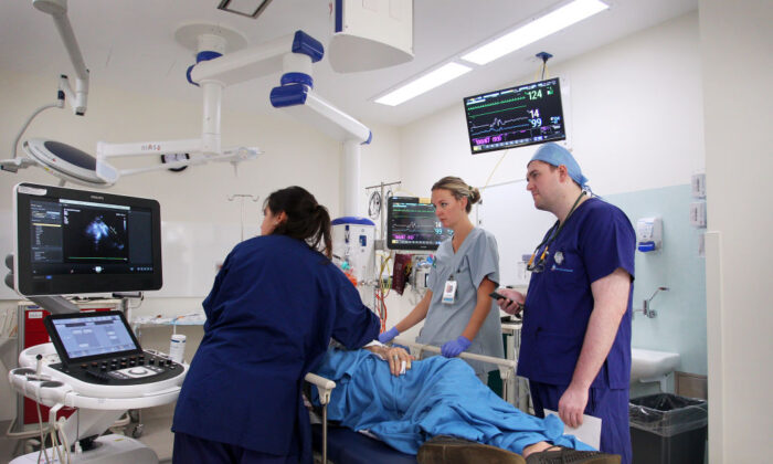 Медицинский персонал скорой помощи и кардиолог Каллум Черретт лечат пациента с подозрением на проблемы с сердцем в отделении неотложной помощи больницы Святого Винсента в Сиднее, Австралия, 4 июня 2020 года. (Lisa Maree Williams/Getty Images)