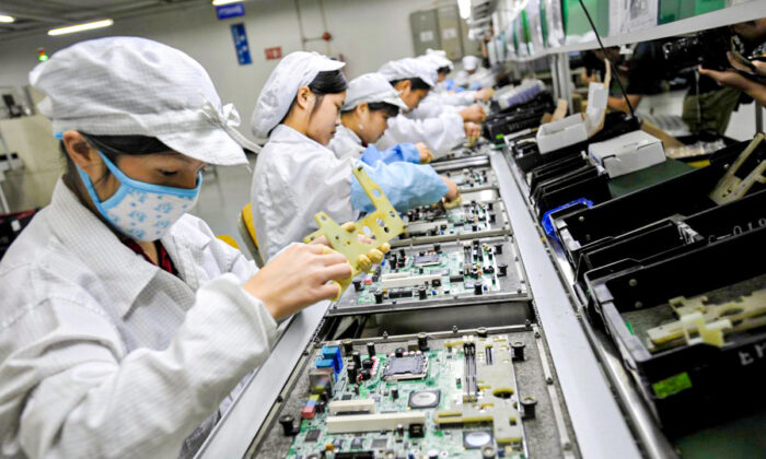 Китайские рабочие собирают электронные компоненты на заводе тайваньского технологического гиганта Foxconn в городе Шэньчжэнь, провинция Гуандун, Китай, 26 мая 2010 года. (AFP/Getty Images)