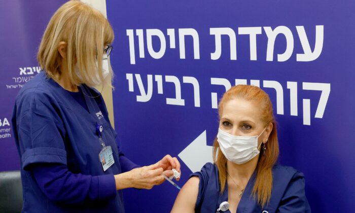 Ізраїльська медсестра отримує четверту дозу вакцини Pfizer-BioNTech проти COVID-19 у медичному центрі Шиба в Рамат-Гані недалеко від Тель-Авіва, 27 грудня 2021 року. (Jack Guez/AFP via Getty Images)