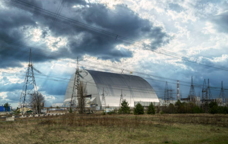 Общий вид на новую защитную оболочку (NSC), которая покрывает старый саркофаг, заключающий в себе остатки поврежденного четвертого реактора, и была повреждена в результате удара беспилотника в ходе продолжающейся российской атаки. (Іstockphoto)