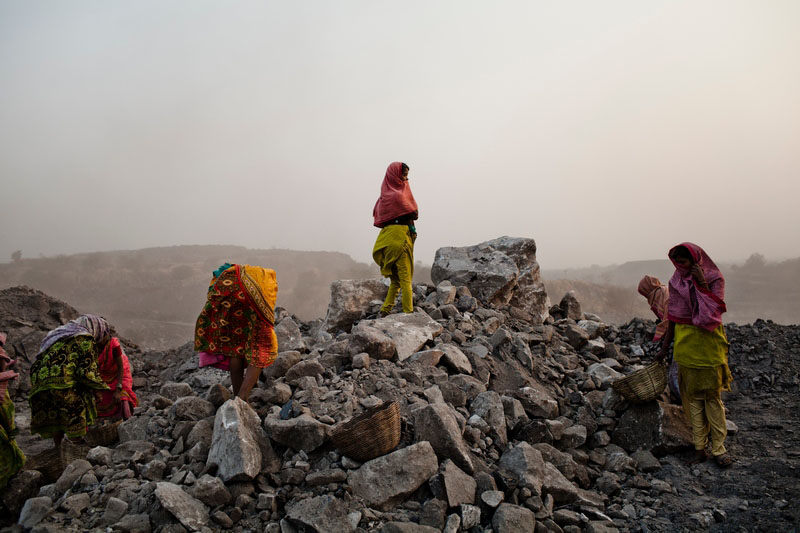 Жінки ховаються від вітру, який несе вугільний пил. Фото: Daniel Berehulak/Getty Images 