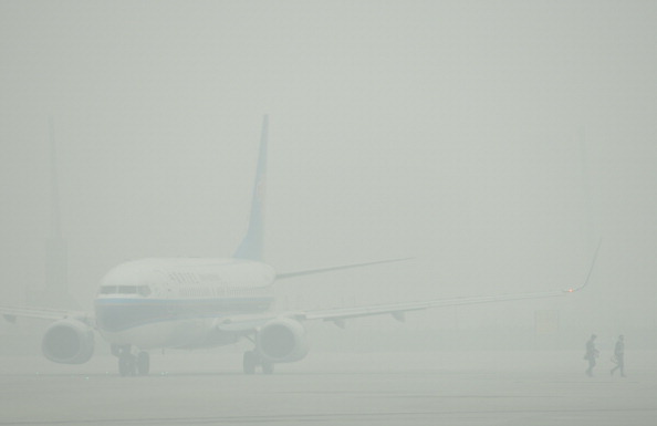 Самолёт с трудом можно рассмотреть сквозь смог в Шанхае, 5 декабря 2013 г. Фото: PETER PARKS/AFP/Getty Images 