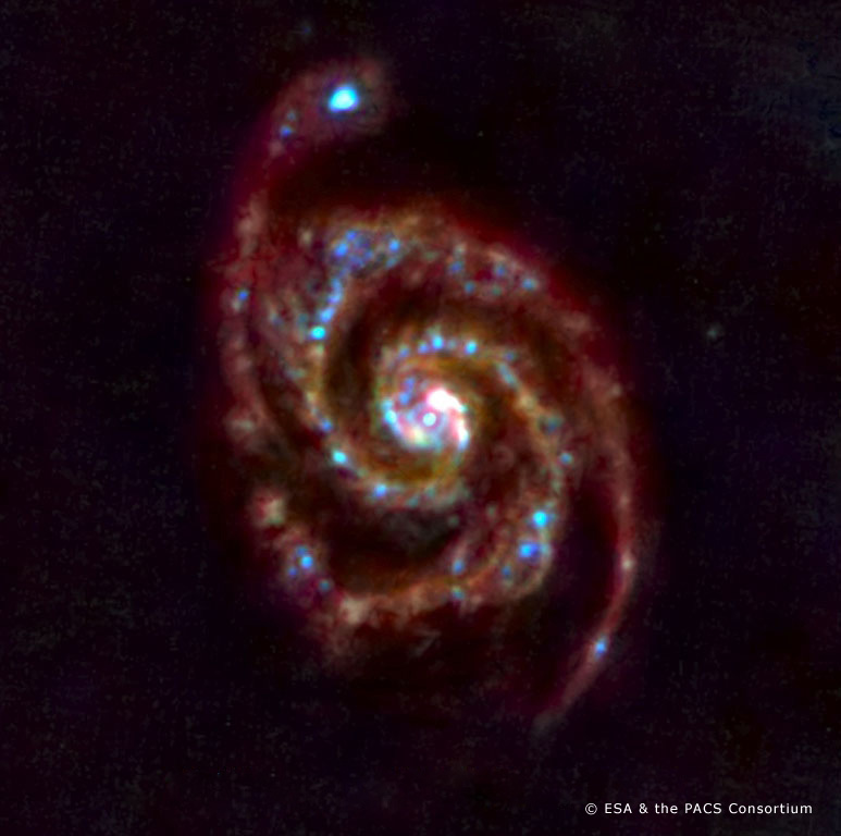 Первый тестовый снимок спиральной галактики М51, 19 июня 2009 года. Голубой цвет — тёплые пыль и газ, красный — более холодное вещество. Фото: ESA and the PACS consortium 