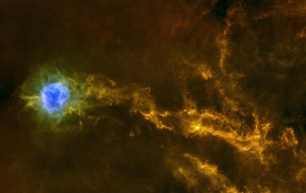 Плотные нити пыли и газа в рассеянном звёздном скоплении IC 5146 (созвездие Лебедя) — источник вещества для молодых светил. Область синего цвета слева — туманность Кокон. Фото: ESA/Herschel/SPIRE/PACS/D. Arzoumanian (CEA Saclay) 