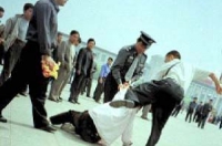 Тиранію знято на камеру: міліціонер заарештовую послідовника Фалуньгун, який прибув на площу Тяньаньмень щоб мирно звернутися із закликів припинити переслідування. 25 липня 2001. (Clearwisdom)