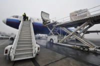 Работники загружают на самолет DC-10 водообрабатывающую установку, отправляемую немецким Красным Крестом в Зимбабве в связи со вспышкой холеры, аэропорт Шонефельд, 17 декабря 2008 г. Фото: John MacDougall /AFP /Getty Images