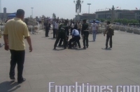 Китайские полицейские задерживают последователя Фалуньгун прямо на улице. Фото: The Epoch Times