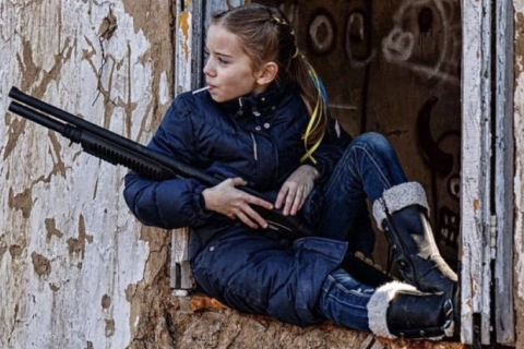 Дитинство в Україні: Дівчина з гвинтівкою і льодяник на паличці. Дональд Туск розповсюджує знімок і надсилає світові послання