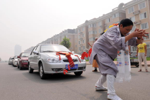 52-річна китаянка протягла 6 автомобілів, прив'язавши їх до своєї коси. ФОТО