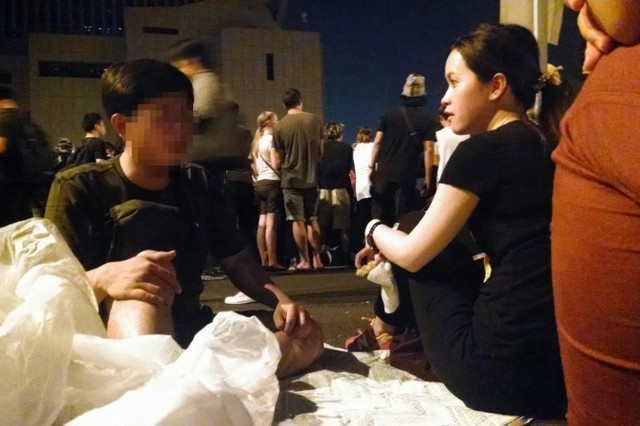 Молодой человек (слева) из материковой части Китая обсуждает альтернативные идеи гонконгской демократии с местной жительницей Гонконга 4 октября 2014 года. Гонконгское движение «Окьюпай» заняло важнейшие дороги вокруг правительственных учреждений в попытке добиться большей демократии