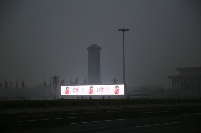 LED-экран показывает китайские иероглифы «Китайская мечта» на площади Тяньаньмэнь в Пекине 26 февраля 2014 г. в то время, как столицу окутал густой смог. Недавно политические лидеры стали уделять больше внимания борьбе с загрязнением.