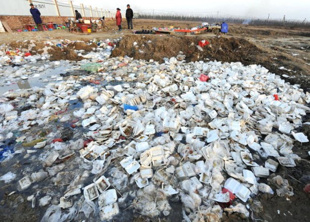Люди на свалке мусора с большим количеством использованной одноразовой посуды неподалёку от стройплощадки в городе Хэфэй, столице провинции Аньхуэй. 40 тыс. округов и около 600 тыс. сёл в Китае не имеют систем переработки мусора. В результате, ежегодно на их свалках образуется около 280 млн тонн мусора. Фото: Getty Images