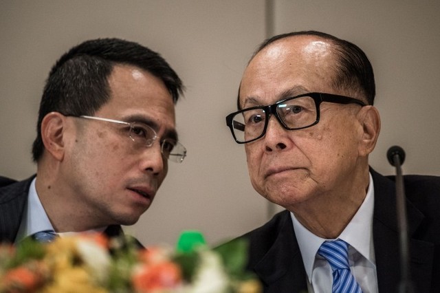 Гонконзький магнат Лі Кашін (праворуч) слухає свого сина Віктора Лі Цар-квоя під час прес-конференції у Гонконгу, 9 січня 2015 року. Нещодавно Лі заявив про плани реорганізувати два підприємства, Cheung Kong Holdings Limited і Hutchison Whampoa Limited, у дві нові компанії, що котируватимуться на гонконзькій фондовій біржі