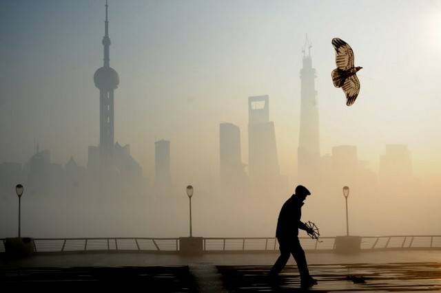 Людина запускає повітряного змія під час важкого смогу на набережній Вайтянь. 5 грудня, Шанхай