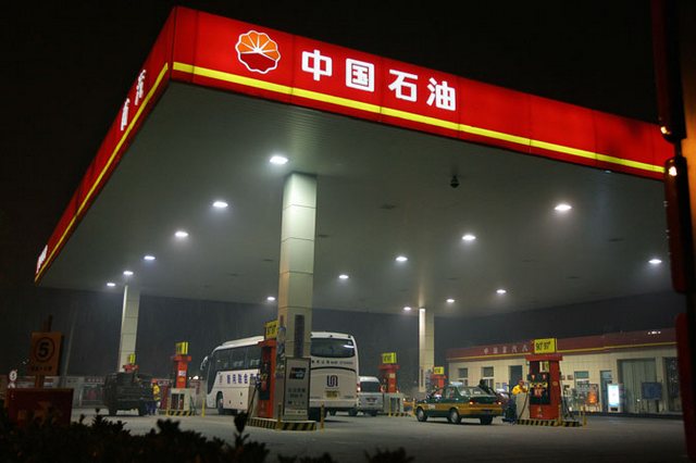 Работники обслуживают клиентов на АЗС PetroChina в Пекине 5 ноября 2007 года