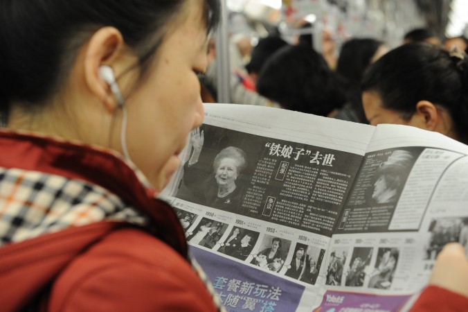 9 квітня 2013 року. Китайська жінка читає новину про смерть колишнього британського прем'єр-міністра Маргарет Тетчер. Нещодавно китайська компартія заборонила використовувати повідомлення іноземних ЗМІ у КНР. Фото: Peter Parks/AFP/Getty Images