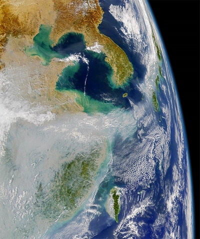 Слева на спутниковом фото запечатлены огромные облака загрязнённого воздуха. Япония находится справа.