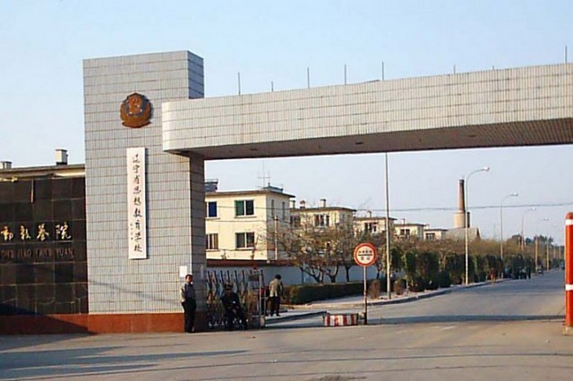 Головні ворота колишнього Жіночого трудового табору Масаньцзя у провінції Ляонін, жовтень 2004 року. Тепер Масаньцзя начебто розділений на наркореабілітаційний центр і в'язницю, хоча ті ж самі ув'язнені і далі страждають там точно так само, як і раніше
