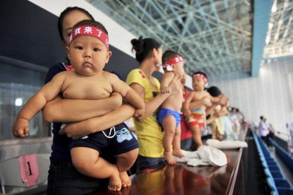 На фото, китайские малыши и их родители готовятся принять участие в конкурсе детского плавания. Фото: STR/Getty Images