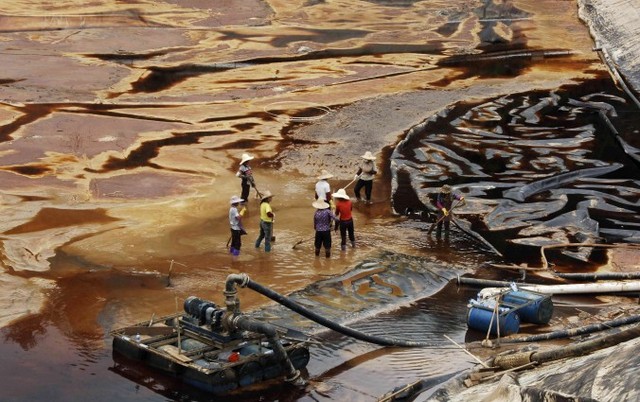 Працівники дренують забруднену воду поблизу мідного рудника Цзицзінь в Шанхані, 2010 р