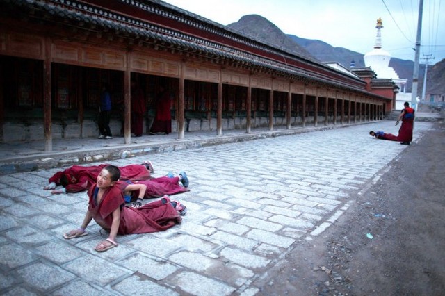 Молодий чернець (ліворуч) 16 травня 2013 року розпростерся поруч із монастирем Лабранг у Сяхе провінції Ганьсу, гарячій точці виникнення багатьох тибетських протестів проти китайської влади