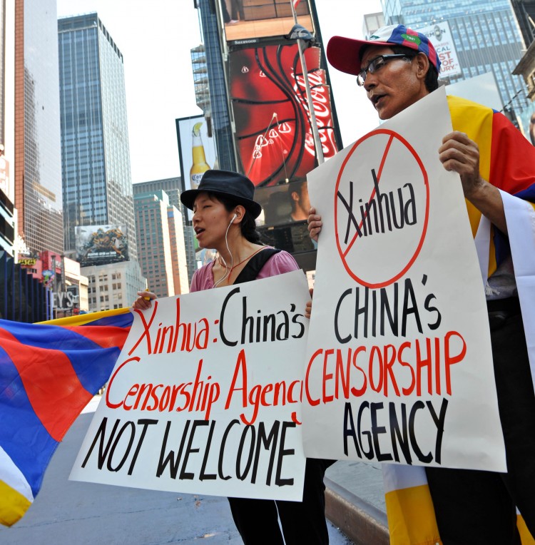 Студенты во время протеста за свободный Тибет в 2011 году на площади Тайм-сквер в Нью-Йорке возле электронного рекламного щита, арендованного пропартийной газетой Синьхуа. Фото: Stan Honda/AFP/Getty Images
