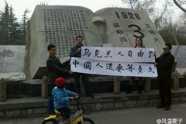 Китай, февраль 2014 г. Четыре человека держат плакаты с надписями: &laquo;Украинцы освободились. Как долго ещё будут ждать китайцы?&raquo; Падение режима Януковича было воспринято многими китайцами как радостная новость.