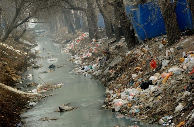 Канал на краю Пекіна забитий сміттям, березень 2012 р. Китай заявляє, що якість повітря двох третин його міст зараз не відповідає новим стандартам